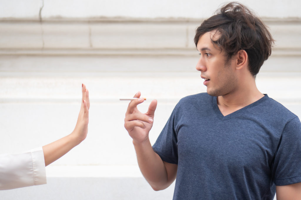 woman hand stopping a man not to smoke; concept of halt, stop smoking, no smoking, smoking prohibited　タバコ